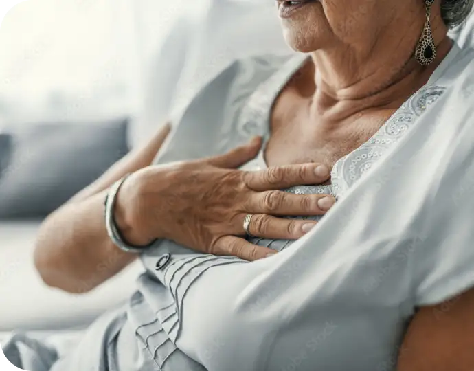 Elderly woman holding her chest experiencing symptoms associated with coronary artery disease