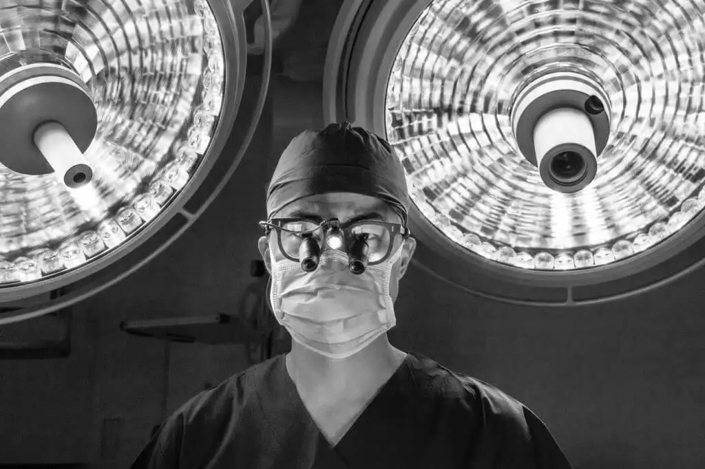 Dr Christopher Cao looking through surgical equipment while performing cardiac surgery in operating theatre