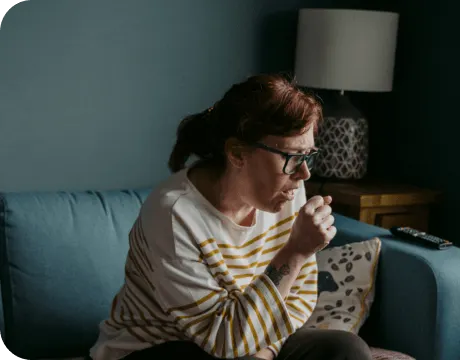 Woman coughing due to symptoms associated with mesothelioma and lung disease